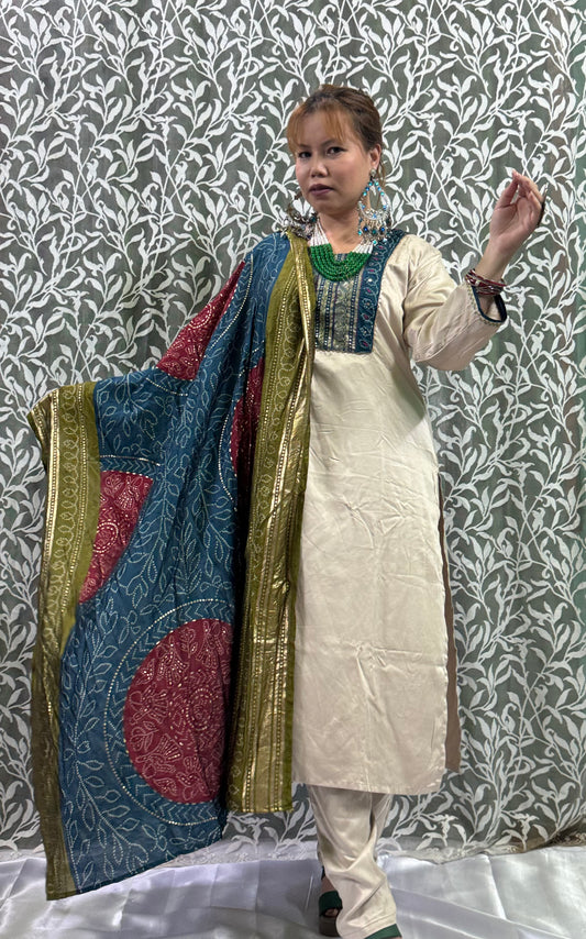 🔹 Color Combination:
• Kurta & Pants: Soft Ivory/Cream
• Neck Embroidery: Deep Blue & Metallic Gold accents
• Dupatta: Rich mix of Teal Blue, Maroon, and Olive Green with traditional Bandhani print and gold zari borders